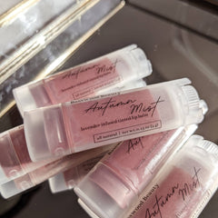 Lip balm tubes with pink tint in clear plastic and white caps, Basswood Beauty label visible
