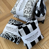 Reusable hand warmers, black and white patterns, DBC brand visible, stacked on wood surface
