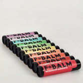 Lip balms in various colors with black caps, F*BALM brand name visible on tubes
