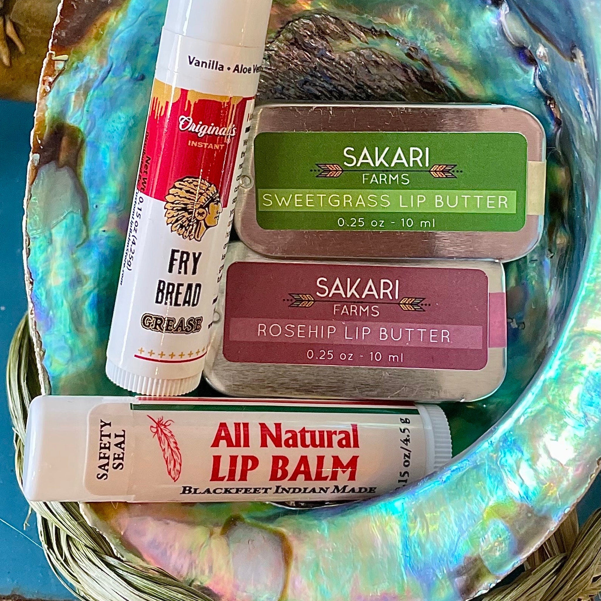 Lip balms and lip butter in white, red, and green tubes and tins, with text labels
