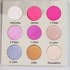 Eyeshadow palette with multiple round pans in pink, purple, gold, and white shimmer shades, with text labels