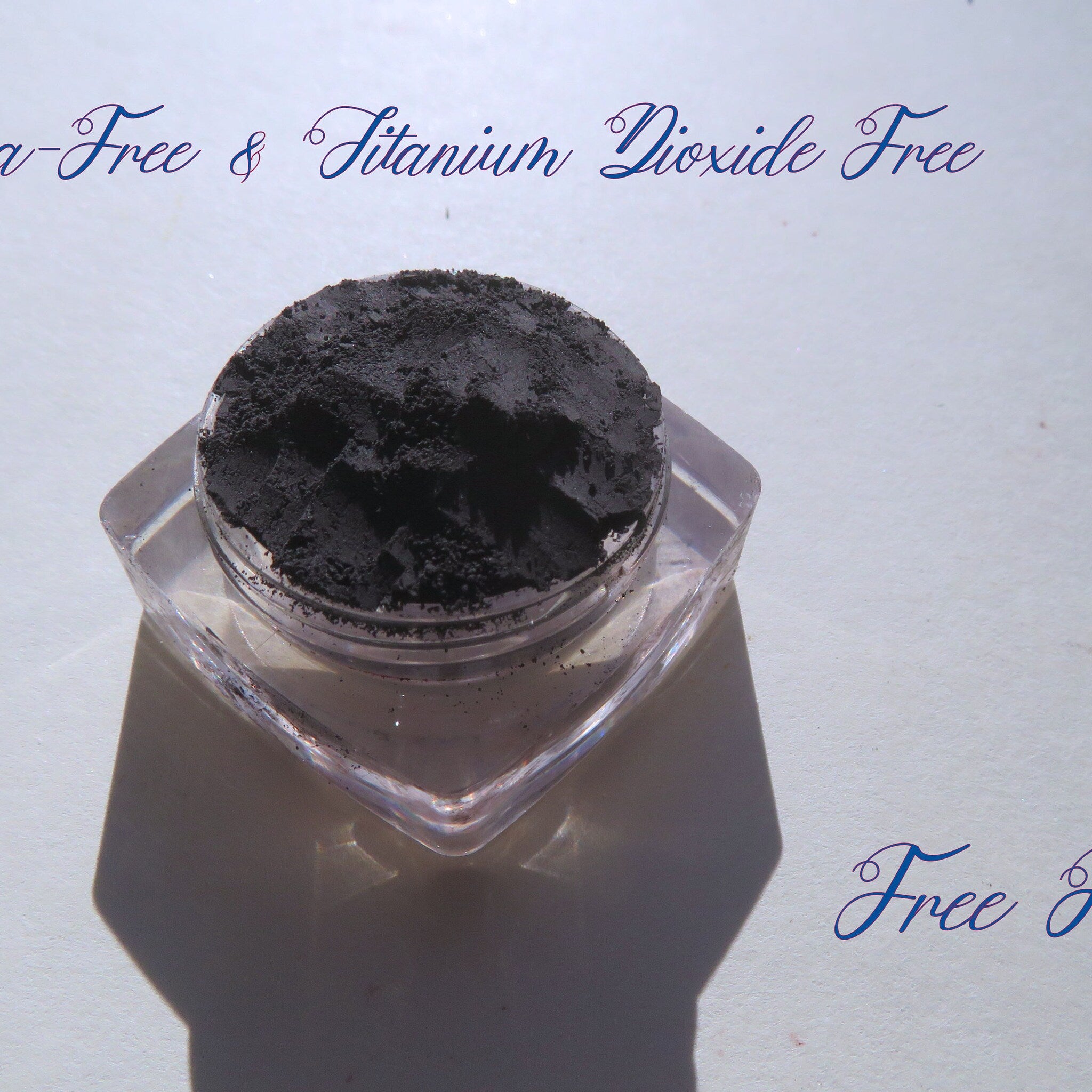 Matte black eyeshadow powder in clear jar, brand "Free Ride" visible