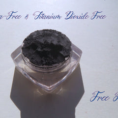 Matte black eyeshadow powder in clear jar, brand "Free Ride" visible