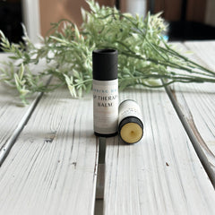Lip therapy balm in black and white cylindrical tubes, with visible Springday Soapery branding on a white wooden surface