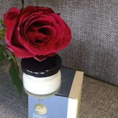 Side view of white moisturizing cream jar with gold lid on marble surface, showcasing texture and packaging details