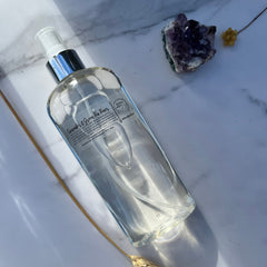 Toner bottle with clear liquid, silver cap, and brand label on a marble surface