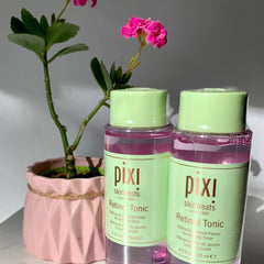 Retinol Toner bottles with green caps and labels, pink liquid, and plant in pink pot with Pixi text