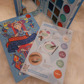 Eyeshadow palette with JCat branding, blue and colorful illustrations, and a how-to guide
