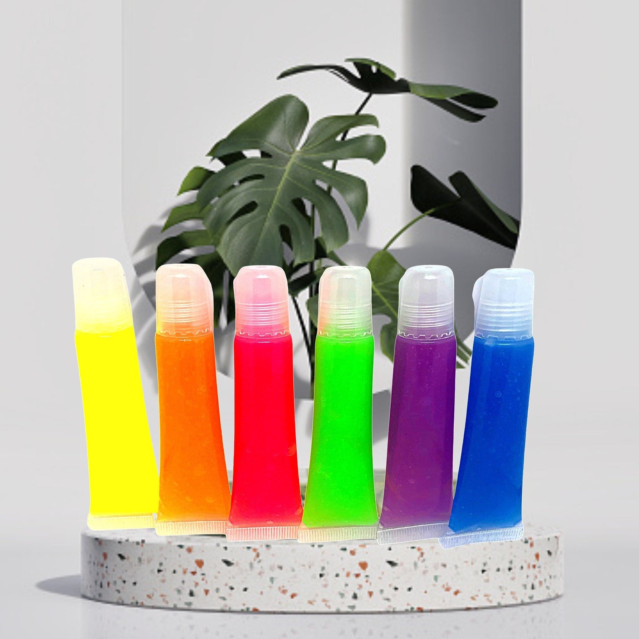 Lip gloss tubes with neon colors, clear plastic, and squeeze style packaging