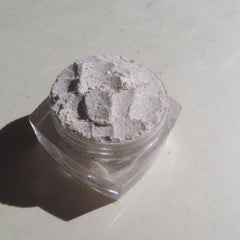 Glitter powder in clear plastic jar, white and sparkly, close-up shot