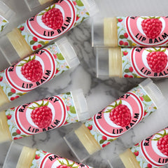 Lip balm tubes with raspberry design, clear plastic, and floral pattern, ready to use