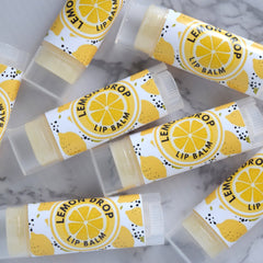 Lip balm tubes with yellow and white labels, clear plastic, and visible "Lemon Drop Lip Balm" text