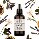 Facial cleanser bottle with Wild Rose label, brown glass, and clear pump top surrounded by botanicals