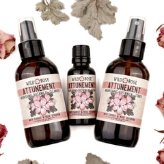 Bottles with black caps and brown glass, with Wild Rose Attunement labels, on white background