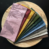 Eye pillow covers in various colors, linen fabric, neatly folded on a wooden tray