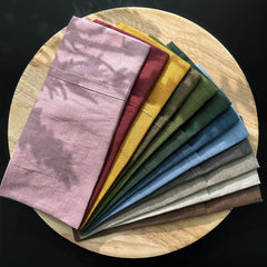 Eye pillow covers in various colors, linen fabric, neatly folded on a wooden tray
