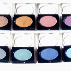 Eyeshadow palettes with various colors and textures in black compacts, arranged in a grid