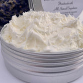 White jar of lavender whipped body butter with natural ingredients label, creamy texture visible