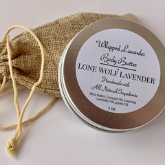 Hand applying lavender whipped body butter to dry skin, showing rich texture and natural glow