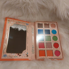 Eyeshadow palette with multiple colors, floral design, and Luxy Charms branding
