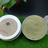 Pain relief cream, open silver tin with green cream, Triple Moon Massage LLC label visible