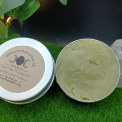 Pain relief cream, open silver tin with green cream, Triple Moon Massage LLC label visible