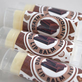 Lip balm tubes with brown and white labels, "Death by Chocolate" text, and clear caps