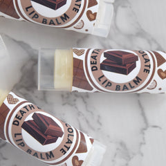 Lip balm tubes with brown and white labels, clear plastic caps, and chocolate design