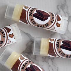 Lip balm tubes with brown patterned labels and clear plastic caps, "Death Lip Balm" text visible