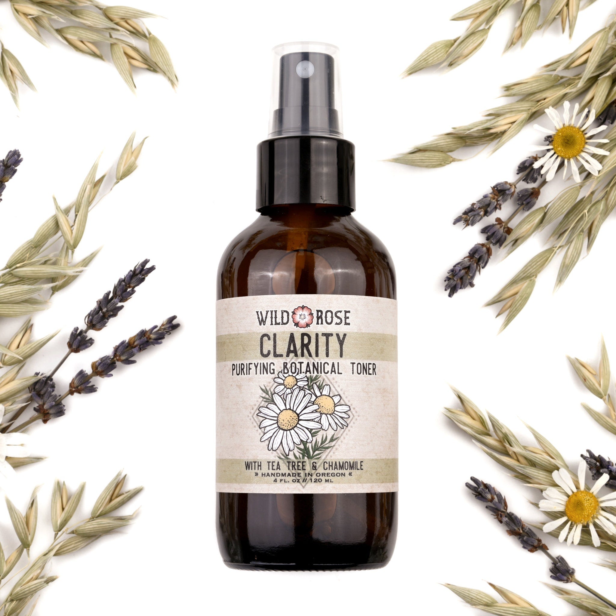 Toner bottle with brown glass, black spray top, and Wild Rose label with flowers surrounded by dried flowers and herbs