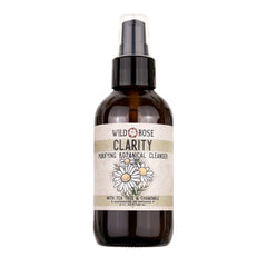 Botanical cleanser bottle with brown glass, white label, and black pump top featuring Wild Rose text