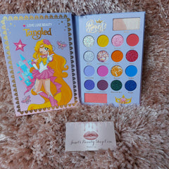 Close-up of Luxi Beauty Tangle Love palette showing twelve vibrant matte and shimmer eyeshadow shades in circular pans