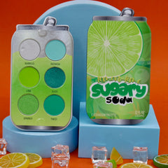 Eyeshadow palette with green, teal, and silver shades in soda can design, "Sugary Soda" text visible