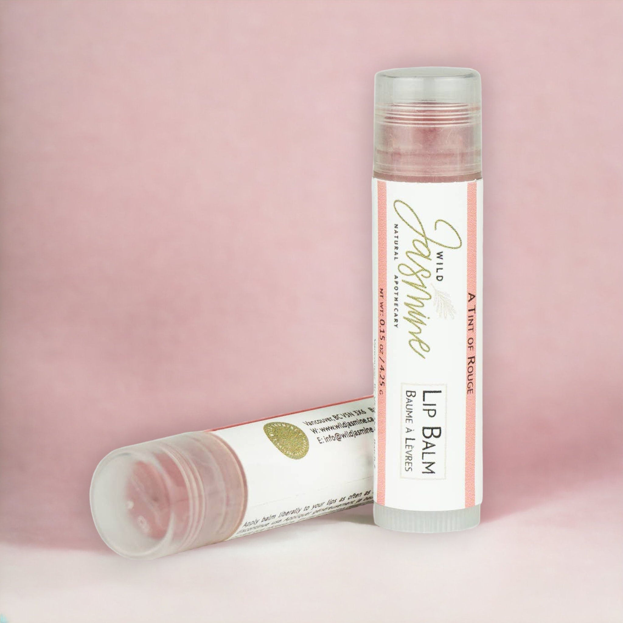Lip balm tubes with red tint, clear plastic, and Wild Jasmine branding on white labels