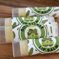 Lip balm tubes with green and white labels, clear plastic, and yellow balm inside