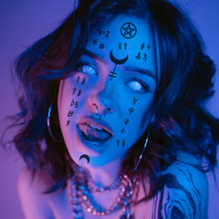 Close-up of intricate Wiccan face tattoo designs with delicate linework and mystical symbols on skin