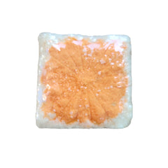 Orange and white square with a leaf pattern, possibly a bath bomb