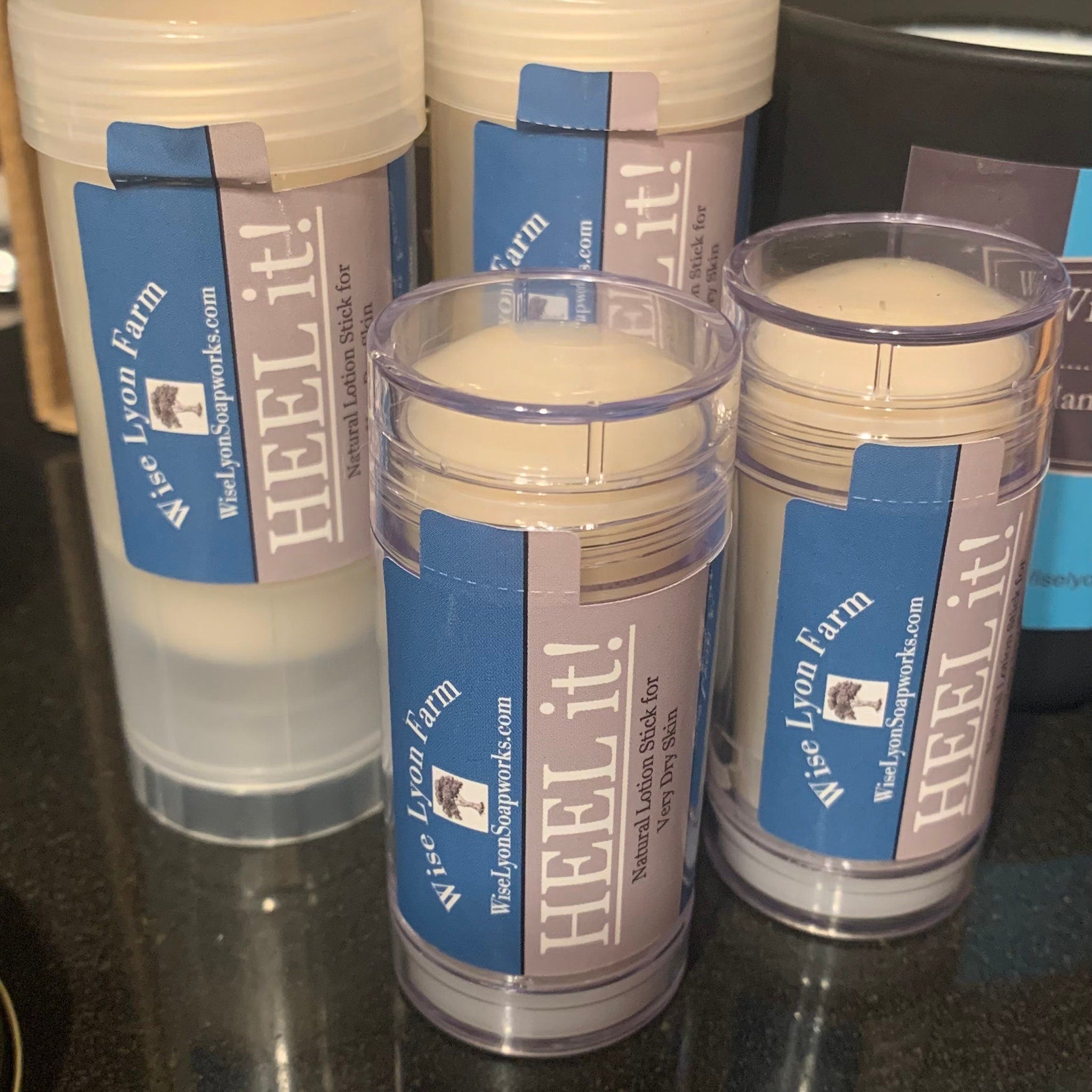 Lotion stick with clear plastic container, blue and lavender label, and Wisely Lyon Farm text