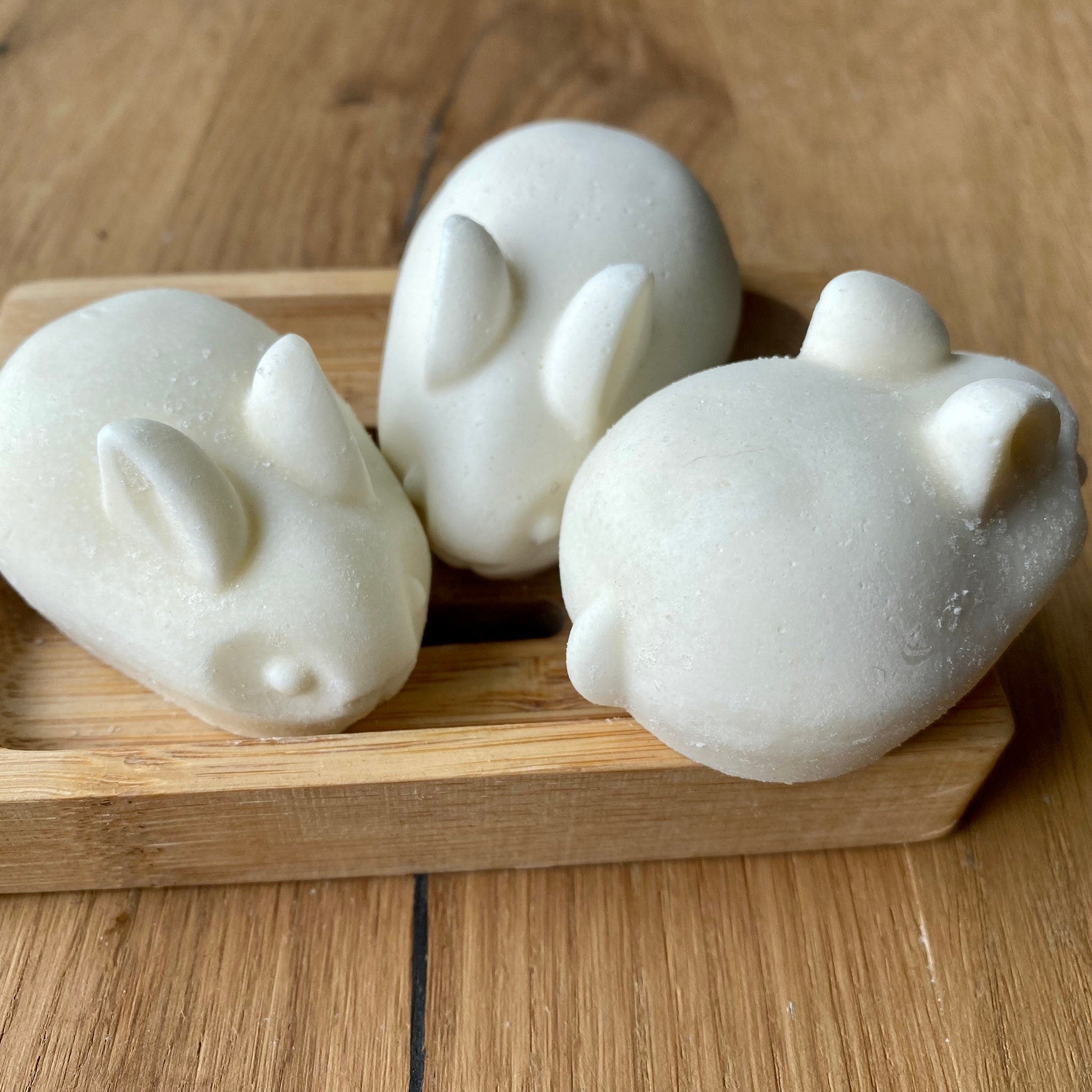 Bar soap rabbit-shaped white, textured soap on wooden tray and table