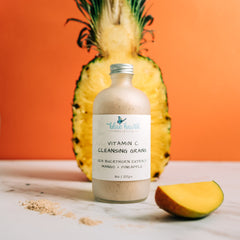 Vitamin C Cleansing Grains bottle with frosted glass, silver cap, and Blue Haven Holistics label, with mango and pineapple