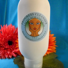 Cleanser bottle, white plastic, Progress Cleanser label, orange and red flowers in background