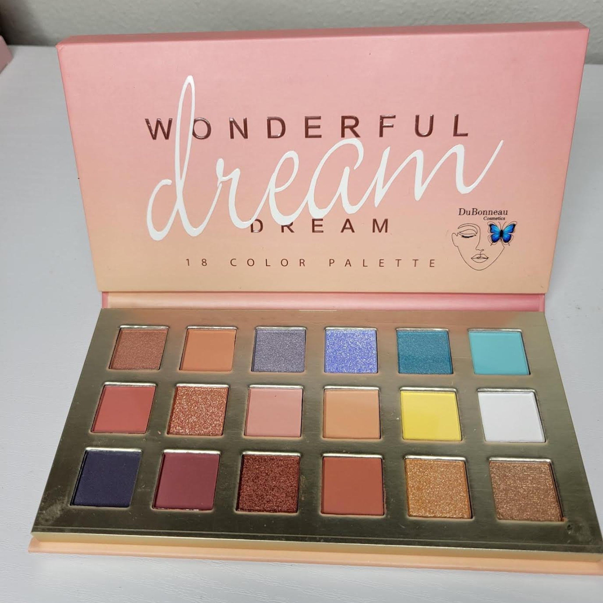 Close-up of Wonderful Dreams Eye Shadow palette showing six shimmering pastel shades in a sleek black compact