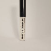 Lip gloss tube with black cap, clear gloss, and Ivory & Obsidian text