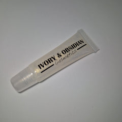 Lip gloss tube with clear, glittery liquid, and Ivory & Obsidian Cosmetics branding