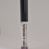 Lip gloss tube with black cap, clear gloss, and Ivory & Obsidian Cosmetics text