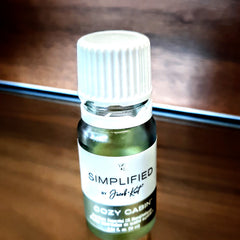 Essential oil bottle with white cap, green glass, and brand label "SIMPLIFIED