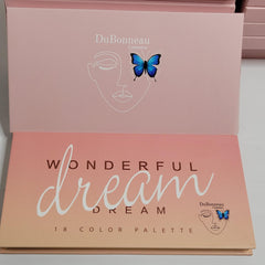 Close-up of fingertips applying shimmery taupe eye shadow to eyelid with soft blending brush