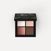 Close-up of six matte and shimmer eye shadow pans in neutral brown, taupe, and champagne shades with black compact.