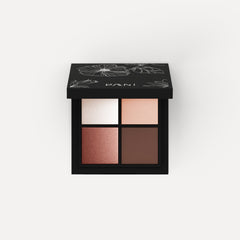 Close-up of six matte and shimmer eye shadow pans in neutral brown, taupe, and champagne shades with black compact.