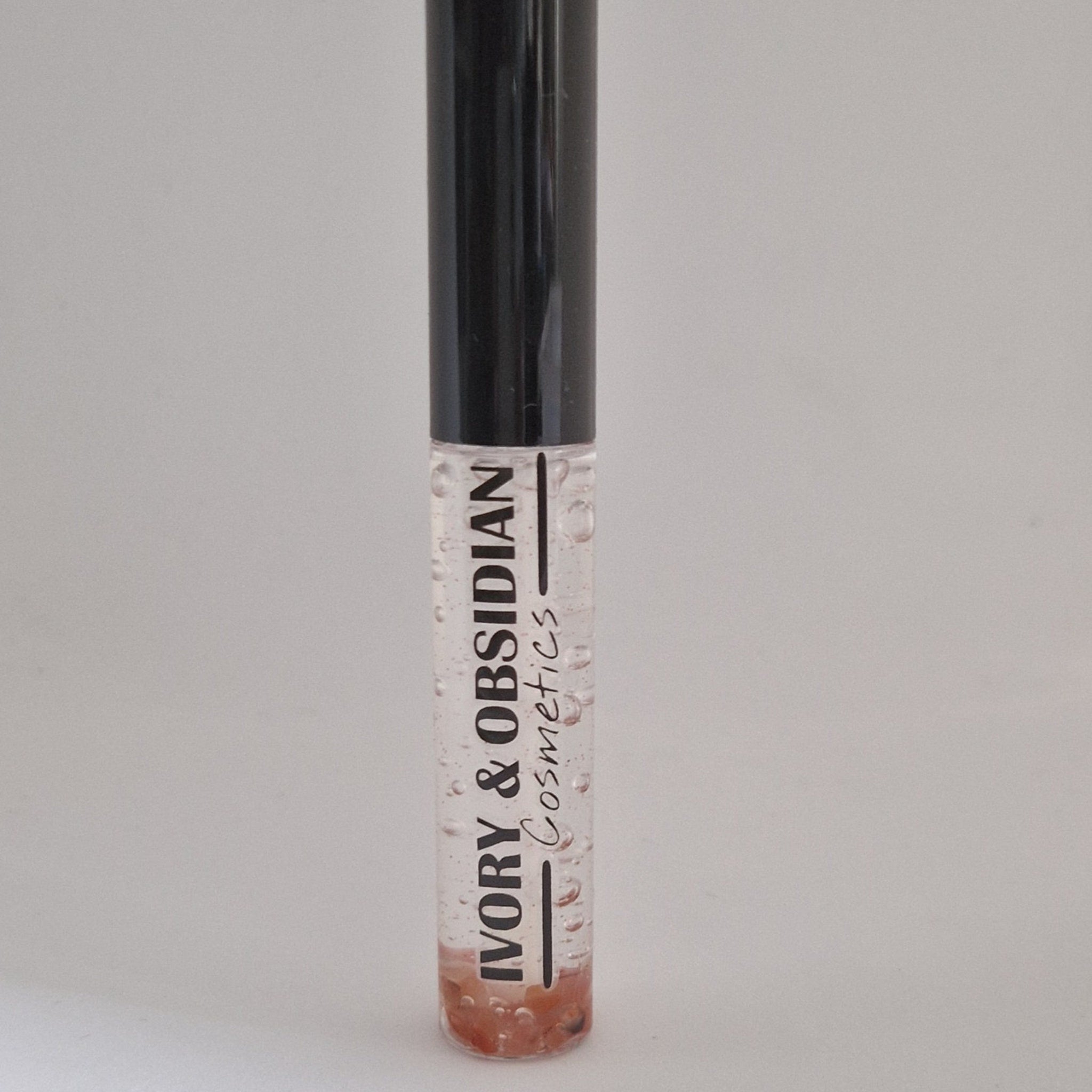 Lip gloss tube with clear liquid, black cap, and Ivory & Obsidian Cosmetics text